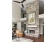 Open living space with soaring stone fireplace, hardwood floors, and flows into kitchen and dining area at 374 Heritage, Woodstock, GA 30188