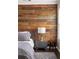 Relaxing main bedroom featuring a rustic wood accent wall, neutral bedding, and a modern nightstand at 374 Heritage, Woodstock, GA 30188