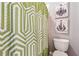 This bathroom features a patterned shower curtain, toilet, and chandelier artwork creating a unique and decorative atmosphere at 4492 Arbor Crest Ct, Suwanee, GA 30024