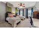 This bedroom features two twin beds, ceiling fan, neutral carpeting, and stylish decor, creating a charming and inviting space at 4492 Arbor Crest Ct, Suwanee, GA 30024