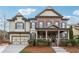 Charming two-story home with brick and siding, featuring a covered porch and well-maintained landscaping at 4492 Arbor Crest Ct, Suwanee, GA 30024