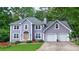 Charming two-story home boasts a well-manicured lawn, inviting entrance, and a convenient two-car garage at 5028 Jamie Ne Ct, Woodstock, GA 30188
