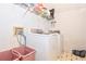 Functional laundry area with front-load washer and dryer, storage shelves, and durable tile flooring at 5028 Jamie Ne Ct, Woodstock, GA 30188