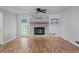 Bright living room showcasing a brick fireplace, wood flooring, and a ceiling fan at 120 Lakeside Dr, Ellenwood, GA 30294