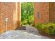 Side yard with gravel pathway between brick buildings leading to a lush backyard at 4417 Village Square Ln, Stone Mountain, GA 30083