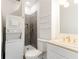 Well-lit bathroom featuring a shower, toilet, sink, and stacked washer and dryer at 4417 Village Square Ln, Stone Mountain, GA 30083