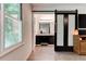 Hallway leading to a bathroom with a barn door, dark vanity, granite counters and good natural light at 4417 Village Square Ln, Stone Mountain, GA 30083