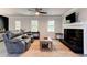 Cozy living room featuring a decorative fireplace, ceiling fan, and lots of natural light at 4417 Village Square Ln, Stone Mountain, GA 30083