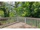 Wooden back deck featuring white railing that overlooks a beautiful, lush back yard at 1585 Olympian Sw Cir, Atlanta, GA 30310