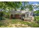 Back exterior with brick and siding, deck, and lush back yard with mature trees at 1585 Olympian Sw Cir, Atlanta, GA 30310