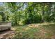 Lush back yard featuring beautiful trees and a deck, perfect for relaxing outdoors at 1585 Olympian Sw Cir, Atlanta, GA 30310