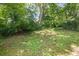 Expansive backyard featuring mature trees and lush greenery, offering privacy and a tranquil outdoor space at 1585 Olympian Sw Cir, Atlanta, GA 30310