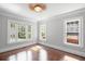 Light-filled bedroom features three large windows, neutral paint, and hardwood floors at 1585 Olympian Sw Cir, Atlanta, GA 30310