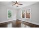 Bright bedroom features hardwood floors and updated ceiling fan and two windows at 1585 Olympian Sw Cir, Atlanta, GA 30310