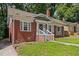 Classic brick home showing the side entry and well-kept front lawn and simple landscaping at 1585 Olympian Sw Cir, Atlanta, GA 30310