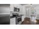 Modern kitchen with white cabinets and stainless steel appliances adjacent to open living area at 1585 Olympian Sw Cir, Atlanta, GA 30310