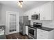 Modern kitchen features stainless steel appliances, white cabinets, and dark countertops at 1585 Olympian Sw Cir, Atlanta, GA 30310