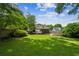 Spacious backyard with lush lawn, mature trees, stone fire pit, and charming back porch perfect for outdoor entertaining at 2545 Tilson Se Dr, Atlanta, GA 30317