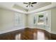 Spacious bedroom featuring hardwood floors, tray ceiling, ceiling fan, and a bay window with plantation shutters at 2545 Tilson Se Dr, Atlanta, GA 30317
