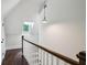 Upstairs hallway with hardwood floors, decorative white wood banister, and a bright window at 2545 Tilson Se Dr, Atlanta, GA 30317