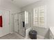 Bright bathroom featuring a glass shower, window with shutters, and neutral color palette at 3427 Hampreston Nw Way, Kennesaw, GA 30144
