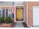 Inviting front entrance featuring a bright yellow door, brick facade, and charming decorative accents at 3427 Hampreston Nw Way, Kennesaw, GA 30144
