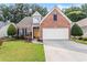 Charming brick home featuring a well-manicured lawn, attached two-car garage and inviting yellow front door at 3427 Hampreston Nw Way, Kennesaw, GA 30144