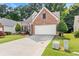 Lovely brick home with green lawn and garden, and a paved driveway leading to an attached garage at 3427 Hampreston Nw Way, Kennesaw, GA 30144
