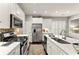 Well-lit kitchen featuring white cabinets, stainless steel appliances, granite countertops, and tile backsplash at 3427 Hampreston Nw Way, Kennesaw, GA 30144