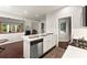 Open-concept kitchen with white cabinets, stainless steel appliances, quartz counters and adjacent living space at 3427 Hampreston Nw Way, Kennesaw, GA 30144