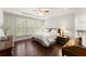 Spacious main bedroom with hardwood floors, tray ceiling, and shuttered windows at 3427 Hampreston Nw Way, Kennesaw, GA 30144
