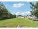 View of a large grassy common area surrounded by trees and townhomes in the community at 2130 Executive Dr, Duluth, GA 30096