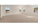 Spacious bedroom with neutral carpet, large windows, and tray ceiling at 271 Sandy Oak Dr, Loganville, GA 30052
