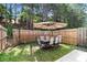 Backyard area featuring an outdoor dining set, privacy fence, and grassy area at 5696 Union Pointe Dr, Union City, GA 30291