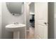 Modern powder room features a stylish pedestal sink, oval mirror, and white paneled door at 5696 Union Pointe Dr, Union City, GA 30291