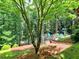Picturesque backyard features an outdoor seating area and playset amid lush greenery and mature trees at 658 Vinings Estates Se Dr, Mableton, GA 30126