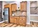 Well-equipped bar area with wood cabinets, stainless steel fridge, sink and backsplash, and close access to stairs at 658 Vinings Estates Se Dr, Mableton, GA 30126