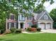 Beautiful two-story home with lush landscaping, brick facade, and attached two-car garage at 658 Vinings Estates Se Dr, Mableton, GA 30126