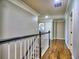 Upper hallway featuring hardwood floors, clean trim, and a staircase with white spindles and a black handrail at 658 Vinings Estates Se Dr, Mableton, GA 30126