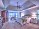 Spacious primary bedroom boasts a tray ceiling, cozy carpet, and windows that bring in the natural light at 658 Vinings Estates Se Dr, Mableton, GA 30126