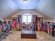 Large walk-in closet with window, storage and custom shelving and center ottoman at 658 Vinings Estates Se Dr, Mableton, GA 30126