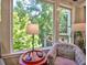 A cozy chair sits by a window showing a scenic view of the trees and outdoor surroundings at 658 Vinings Estates Se Dr, Mableton, GA 30126