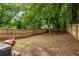 Large fenced backyard with mature trees providing shade and a cozy outdoor space at 1296 Plaza Sw Ave, Atlanta, GA 30310