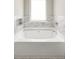 Bright bathtub with a marble tile surround and a large window at 1296 Plaza Sw Ave, Atlanta, GA 30310