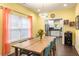 Dining area featuring a large table, hardwood floors, and access to the modern kitchen at 1296 Plaza Sw Ave, Atlanta, GA 30310
