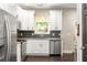 Modern kitchen features white cabinetry, granite countertops, and stainless steel appliances at 1296 Plaza Sw Ave, Atlanta, GA 30310