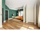 Modern main bedroom featuring stylish wood floors, a ceiling fan, and designer green accent wall at 1296 Plaza Sw Ave, Atlanta, GA 30310