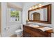 Charming bathroom featuring a wood vanity, decorative mirror, and window for natural light at 1423 Briarcliff Ne Rd, Atlanta, GA 30306