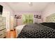 Bedroom boasts light-purple walls, hardwood floors, a large window, and floral prints on the wall at 3372 Springside Rdg, Decatur, GA 30034