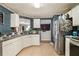 A kitchen features white cabinets, stainless steel appliances, tile flooring, and views into another room at 3372 Springside Rdg, Decatur, GA 30034